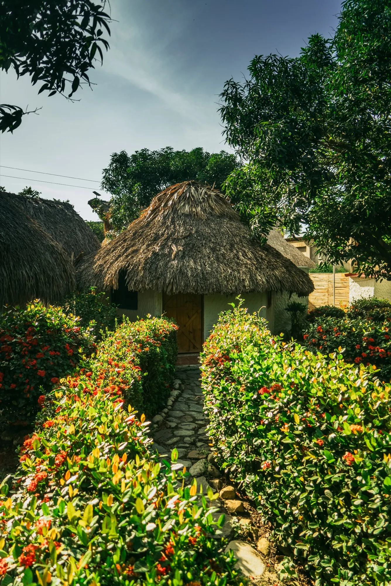 Cabaña con techo de paja entre jardines de Praba Hostel