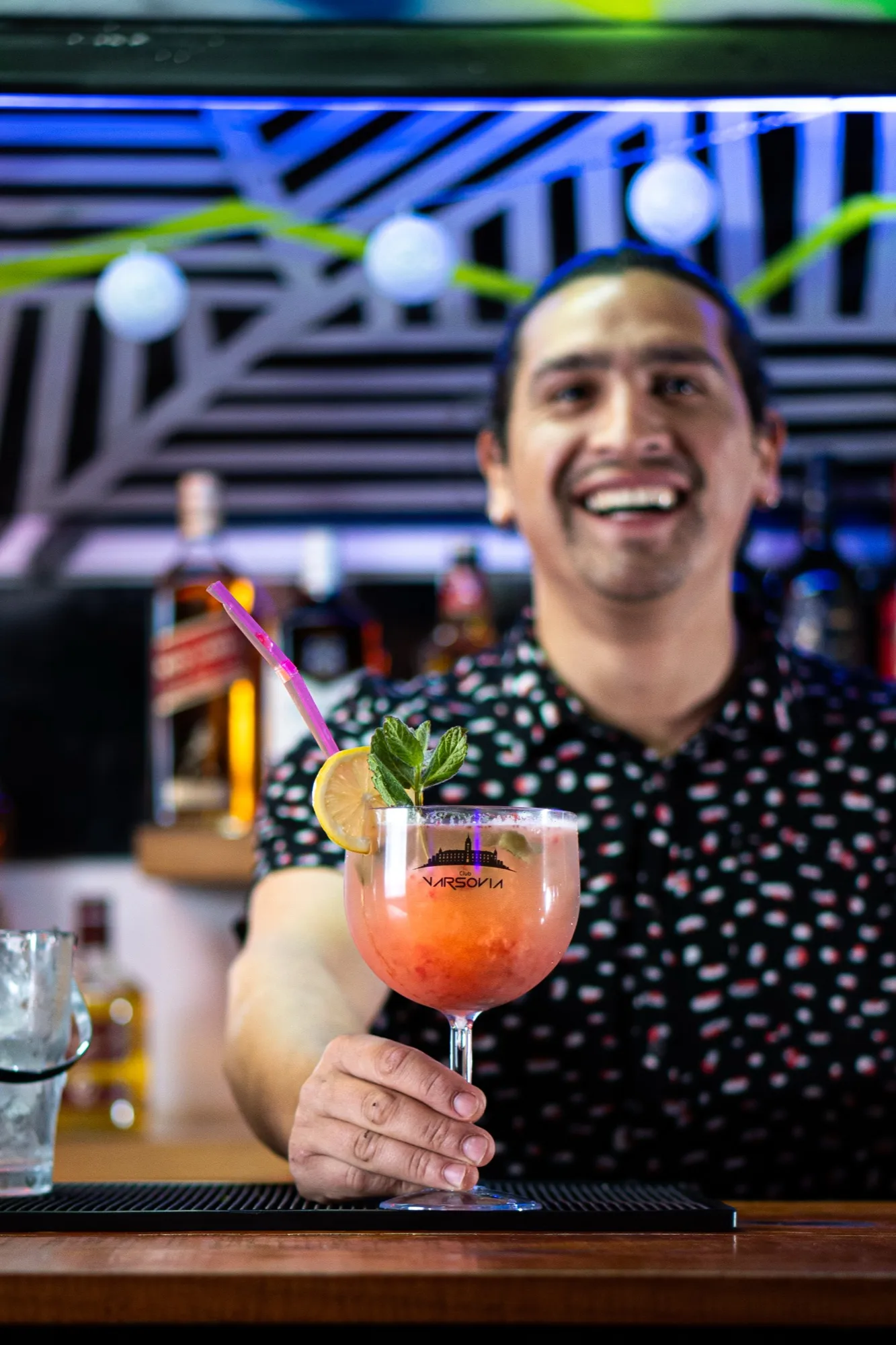 Bartender de Club Varsovia con un cóctel en la mano
