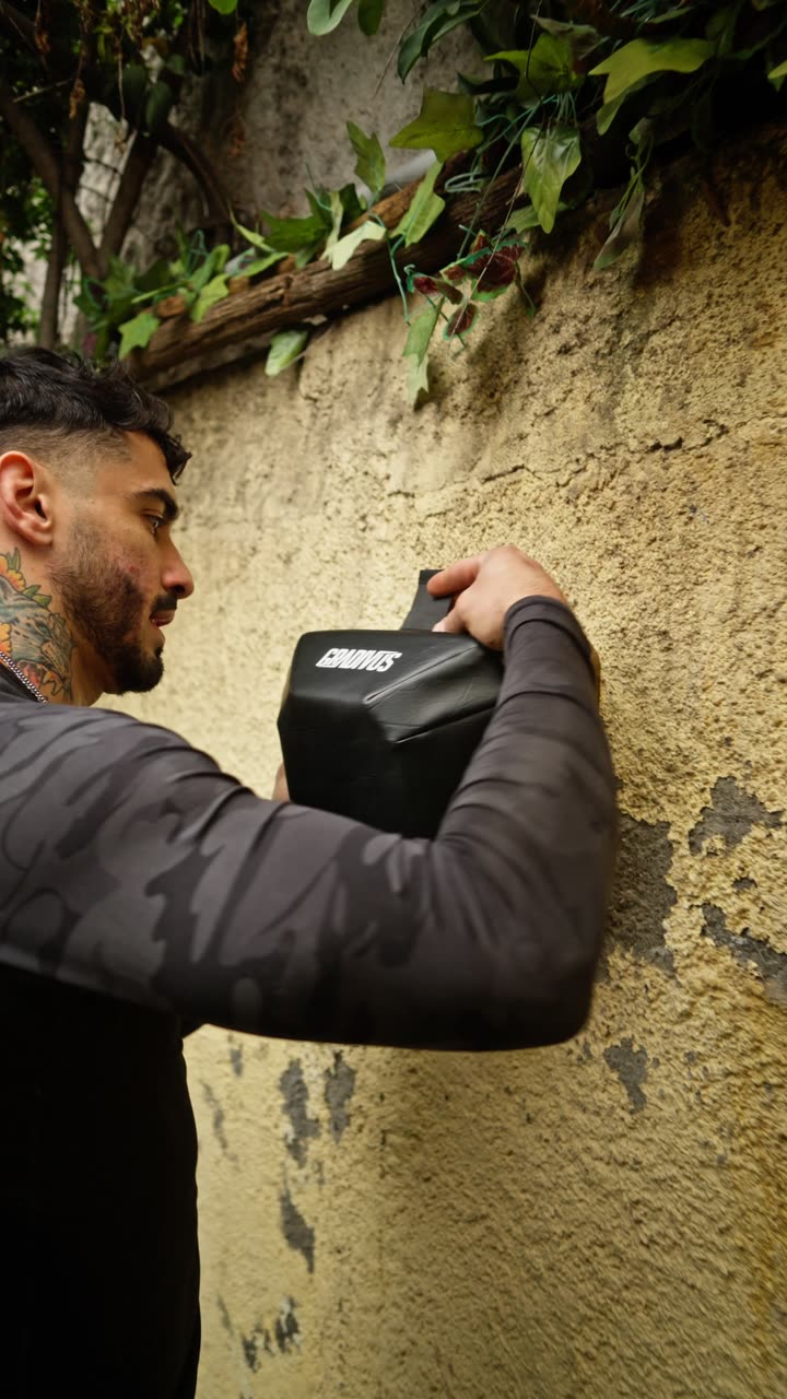 Hombre golpeando el Bully de Gradivus montado en un muro