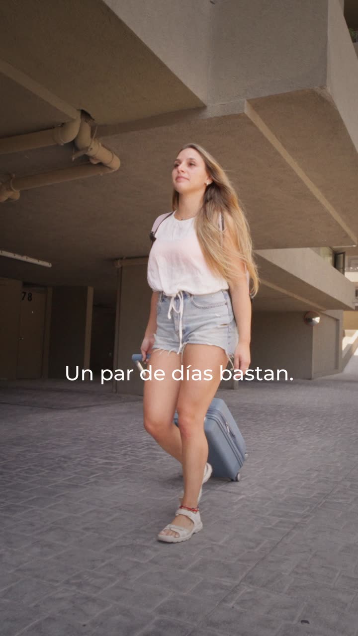 Modelo caminando con su maleta Saxoline por un estacionamiento